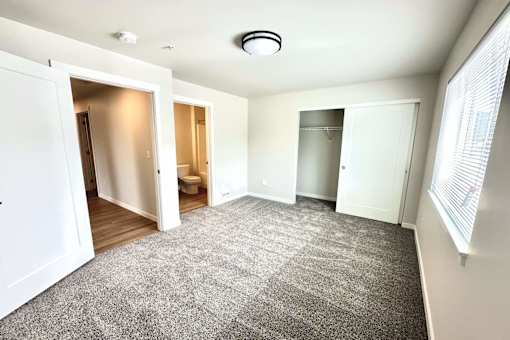 A spacious room with a carpeted floor and white walls.