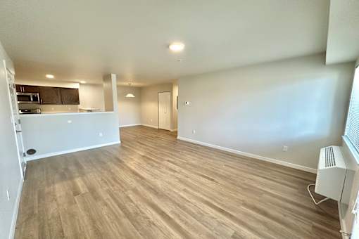 A room with wooden flooring and a white wall.