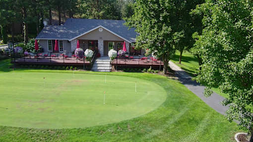 A house with a green lawn in front of it.