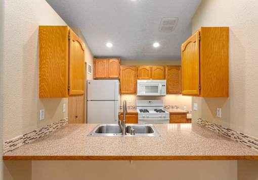 A kitchen with wooden cabinets and a white refrigerator.
