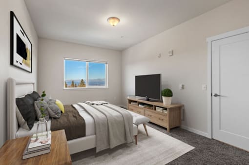 A bedroom with a bed, a television, and a window overlooking the mountains.