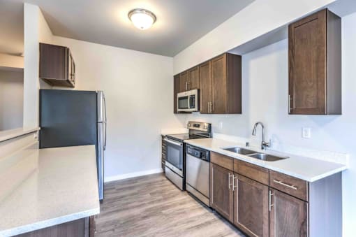 A kitchen with a black refrigerator, microwave, and stove.