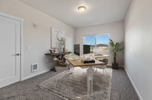 A room with a desk, chairs, and a window.