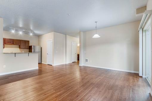 A large empty room with wooden floors and white walls.