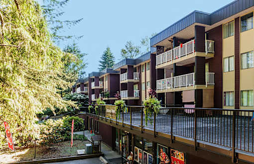 an apartment complex with balconies and trees