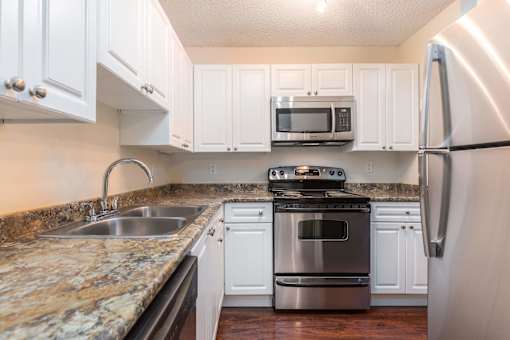 a kitchen with white cabinets and granite countertops