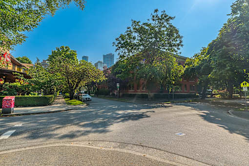 A tree-lined street with a car parked on the side.