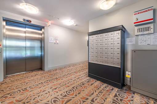 A room with a patterned carpet and a large electrical panel on the wall.