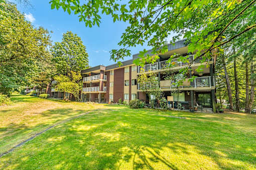 A large grassy area in front of apartment buildings.