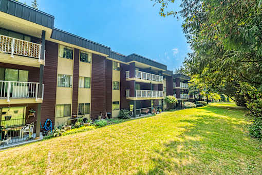 Apartment complex with green grass in front.