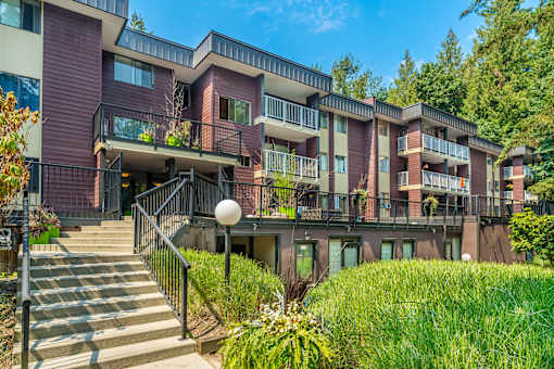 A modern apartment building with a staircase leading to the entrance.