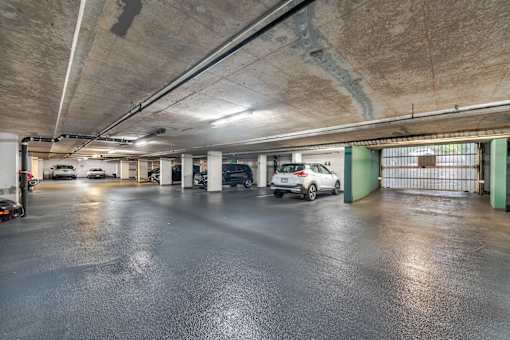 A car is parked in a large, empty parking garage.