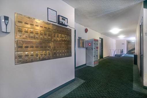 A long hallway with a wall of mailboxes on the left.