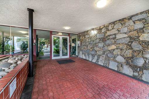 A stone wall with a glass door and windows.