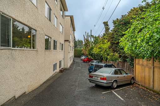 A car is parked on the side of a narrow street.
