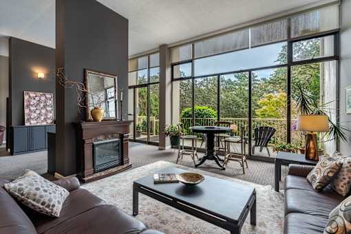 A living room with a fireplace and a glass table.