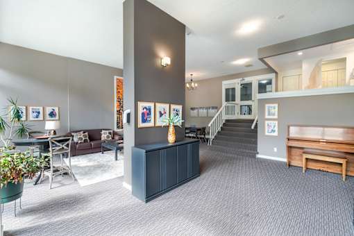 A living room with a dark blue cabinet and a staircase.
