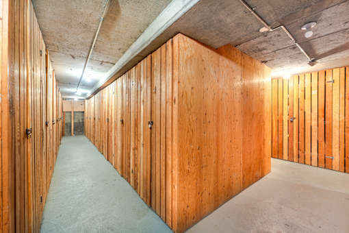 A long hallway with wooden walls and doors on both sides.