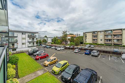 A parking lot with cars and apartment buildings in the background.