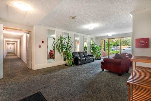 A hallway with a red couch and a wooden bench.