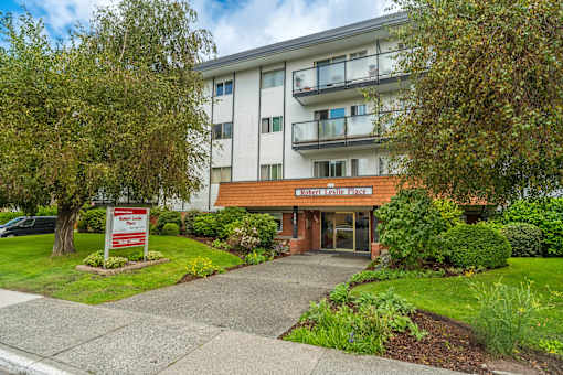 A building with a sign that says "Welcome to Maplewood Apartments".