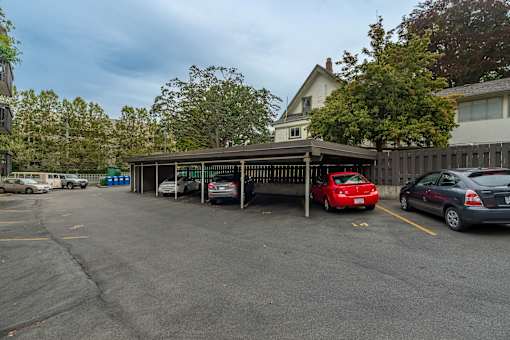 A parking lot with cars and a building in the background.