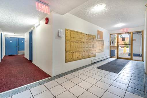 A hallway with a red exit sign above the door.