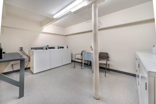 A room with a white cabinet, a chair, and a table.