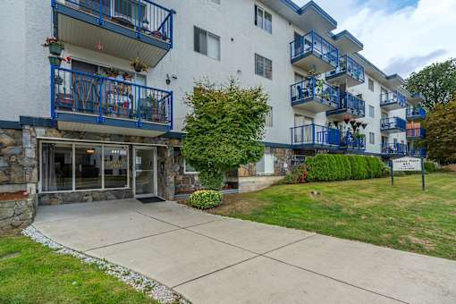 A white building with blue railings and a balcony.