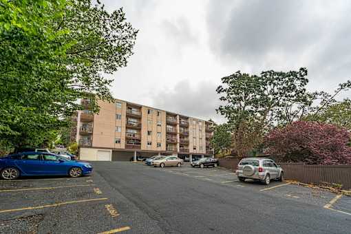 A parking lot with cars and a building in the background.