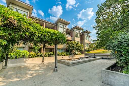 A modern house with a large front yard and a concrete walkway.