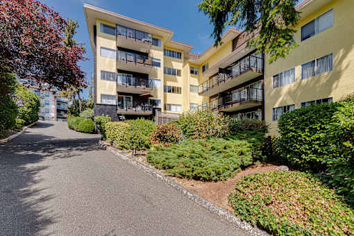 Apartment building with a paved road in front.