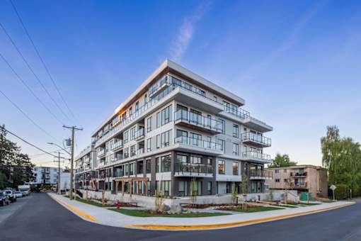 A modern multi-story building with balconies and large windows.