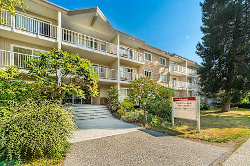 A building with a sign that says "Cold Springs Apartments" in front of it.