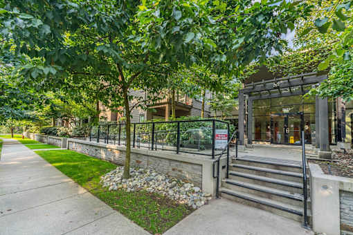 A building entrance with a metal railing and steps leading up to it.
