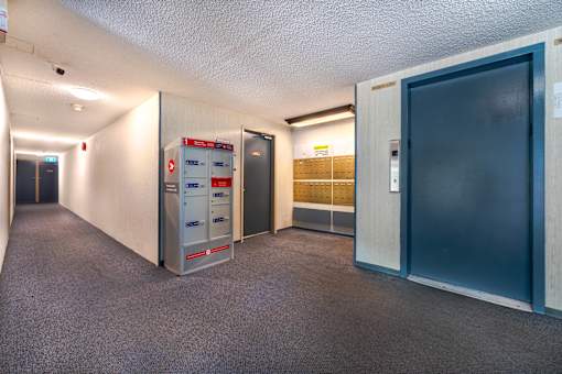 A hallway with a mailbox and a filing cabinet.