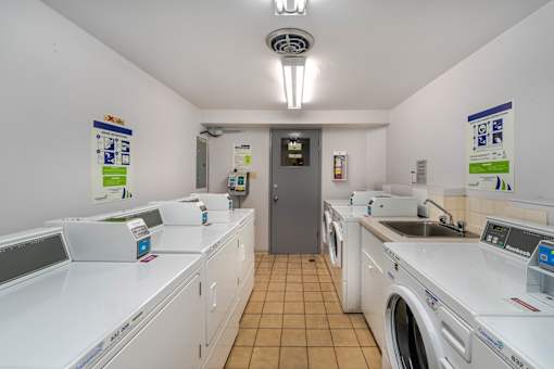 A laundromat with a row of washers and dryers.