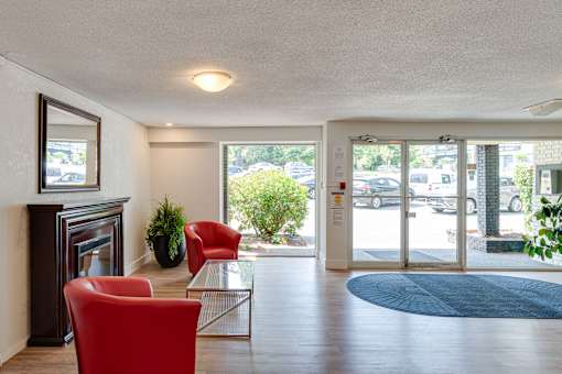 A living room with a fireplace, two chairs, and a coffee table.
