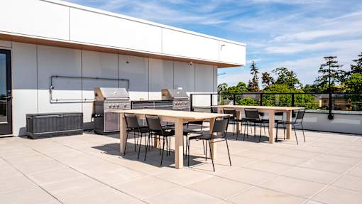 A white building with a table and chairs outside.