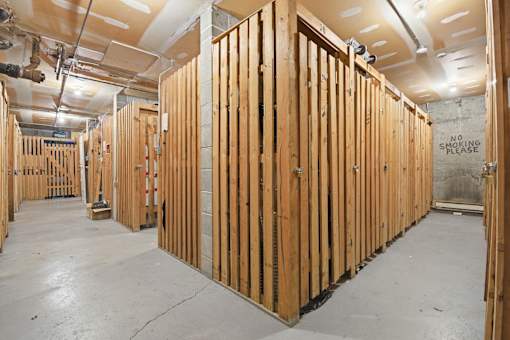 A room under construction with wooden studs and a "No Smoking Please" sign on the wall.