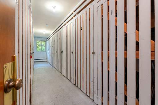 A long hallway with a door on the left and numbered doors on the right.