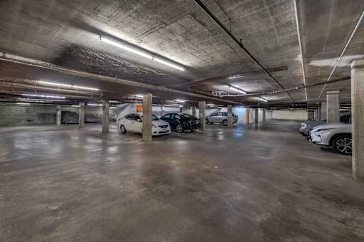 A parking garage with several cars parked inside.