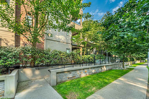 A concrete pathway leads through a grassy area in front of a building.