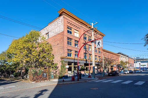 A street view of a red brick building with a clear blue sky.