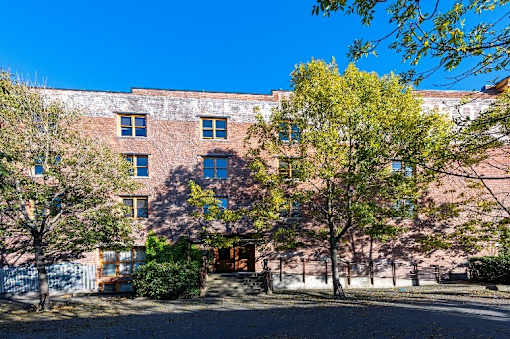 A red brick building with trees in front.