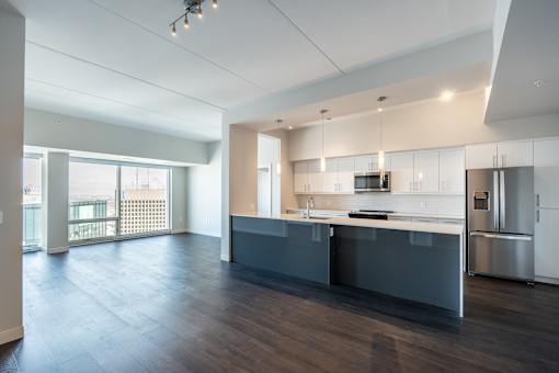 A modern kitchen with a large island and stainless steel appliances.