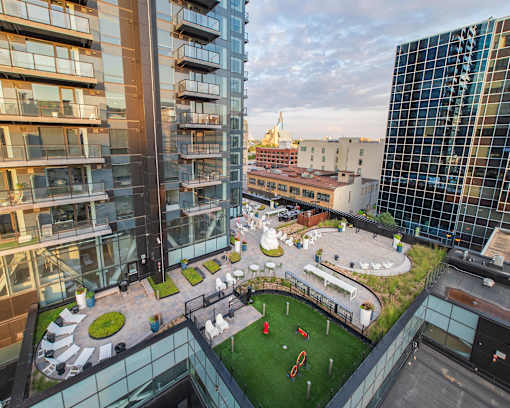 A modern glass building with a green space in the courtyard.