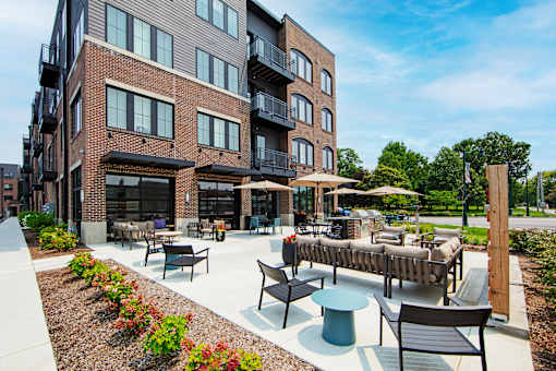 a patio with tables and chairs outside of a building
