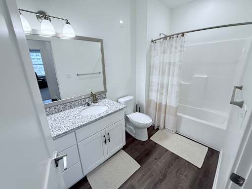 A white bathroom with a sink, toilet, and bathtub.
