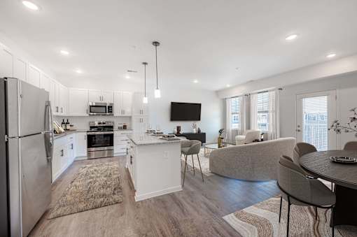 A modern kitchen with a refrigerator, oven, and sink.